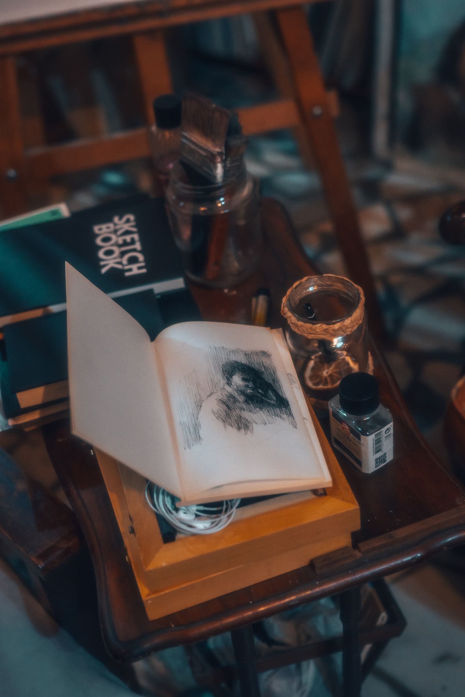 Sketchbooks and brushes arranged on a studio table