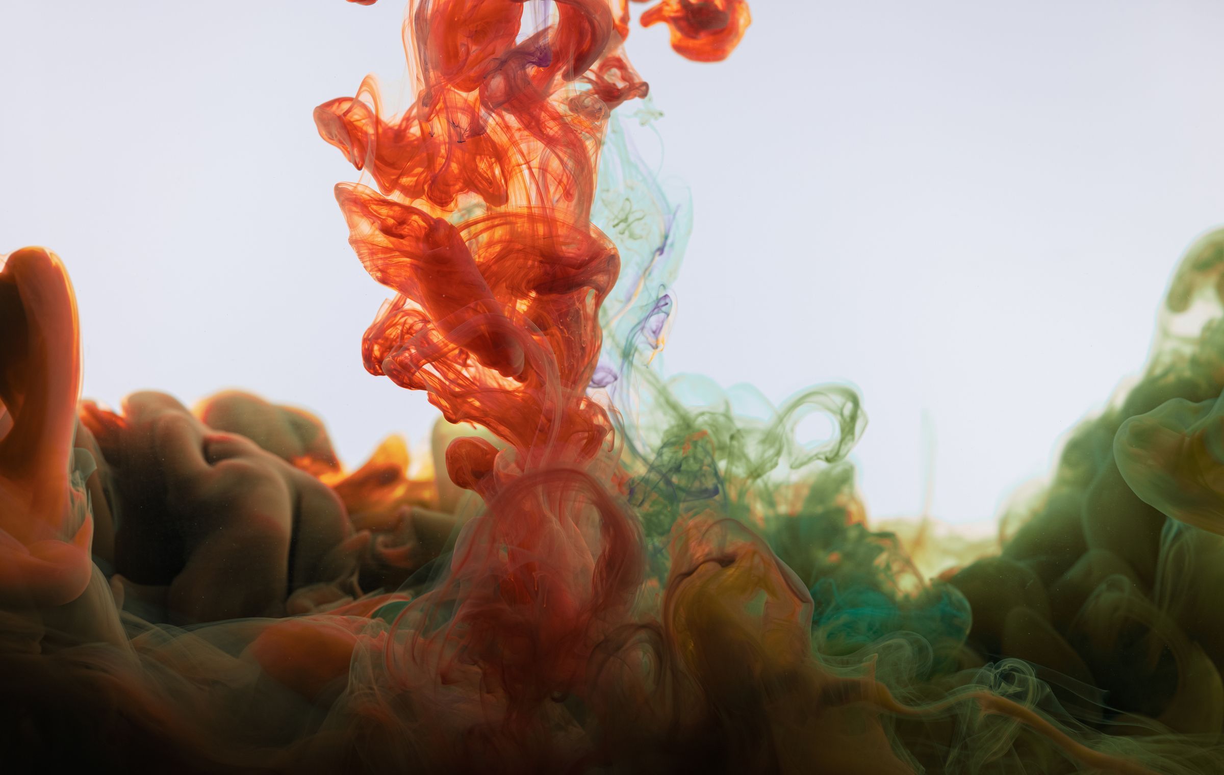 Orange and ochre ink diffusing through water
