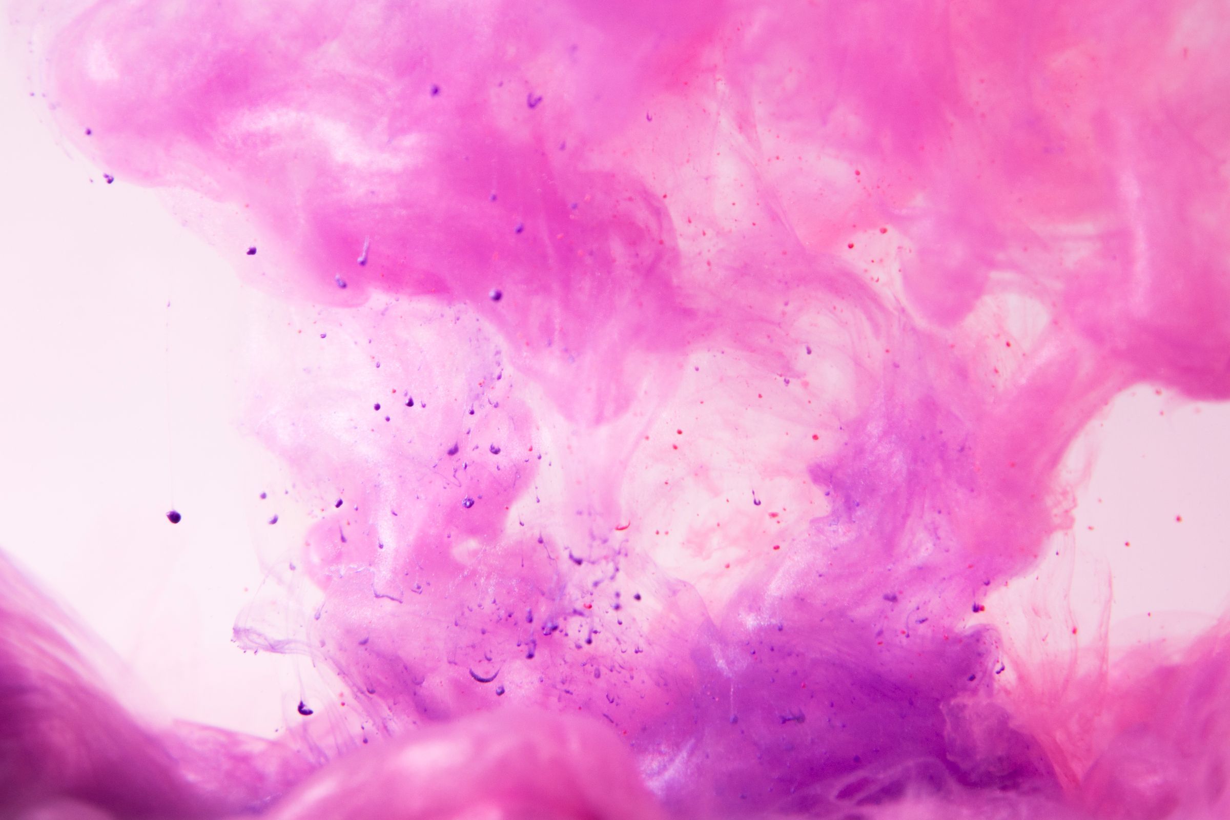 Pink and purple pigment swirling in water