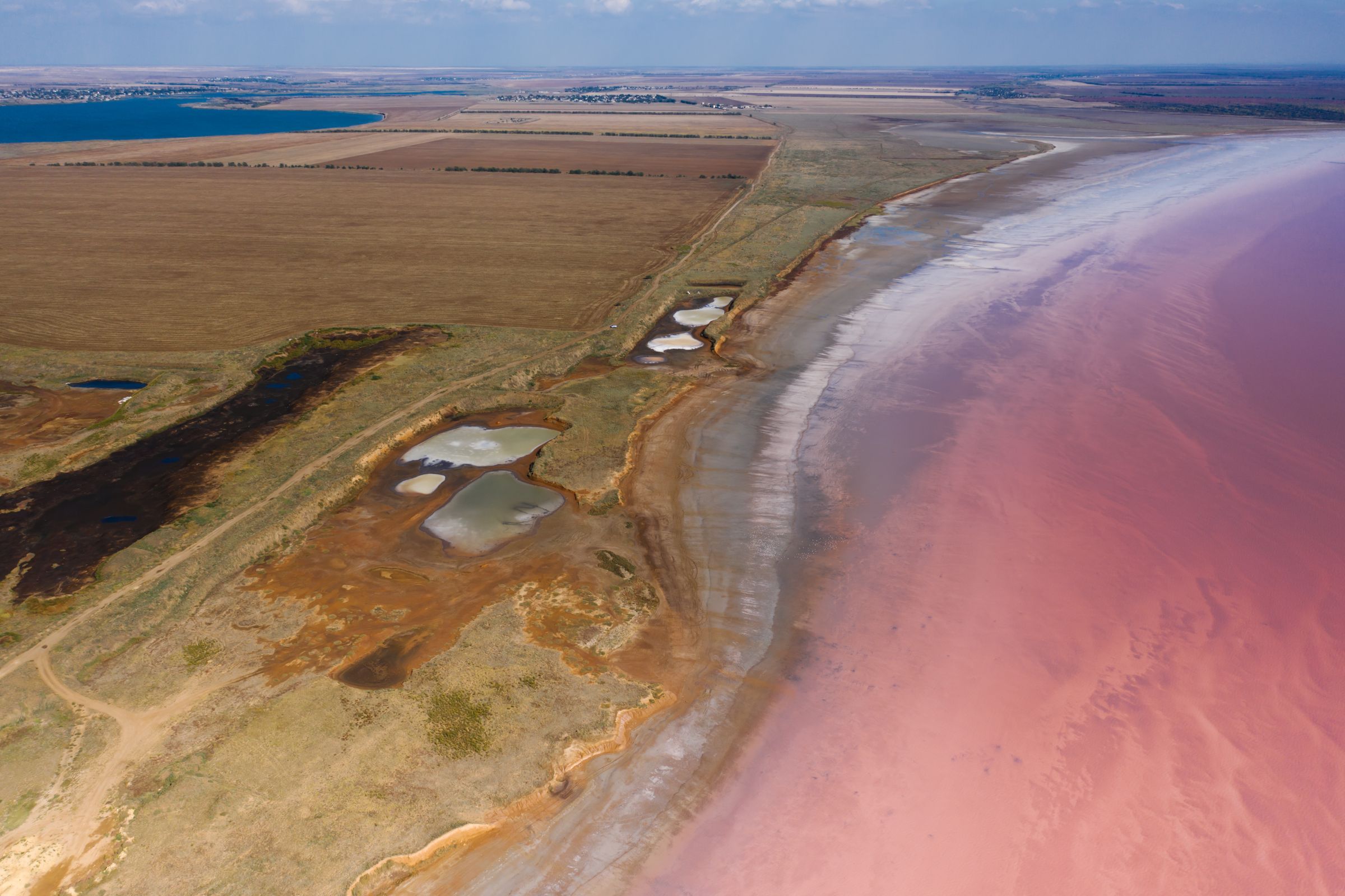 Pink salt lake and earthy terrain seen from above
